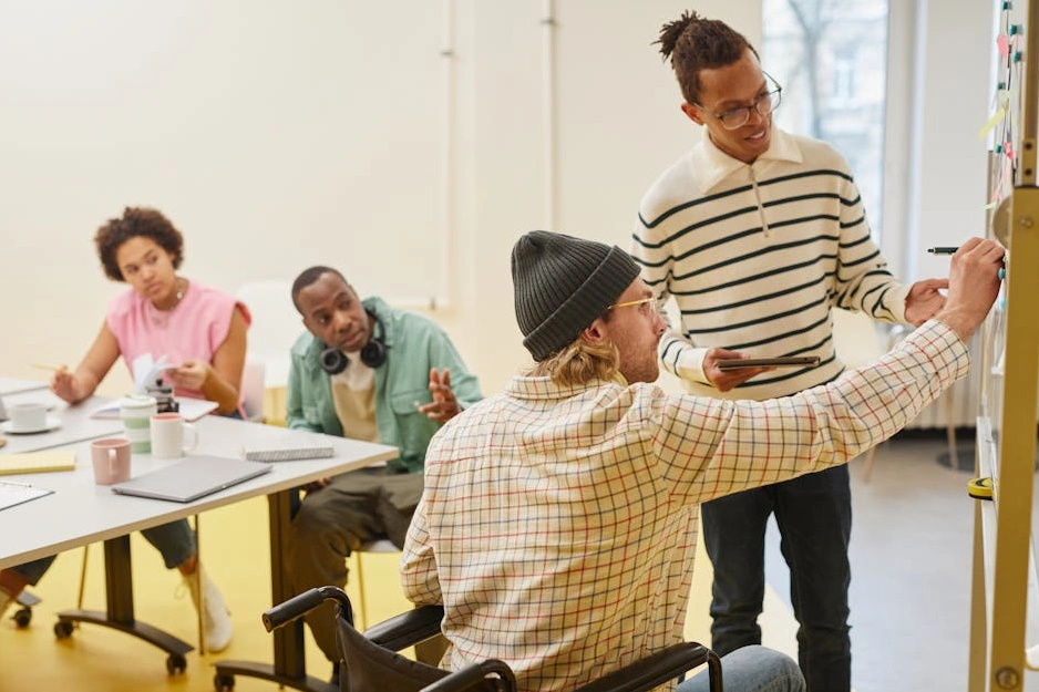 Zróżnicowany zespół specjalistów dyskutujący nad projektem w nowoczesnym biurze.